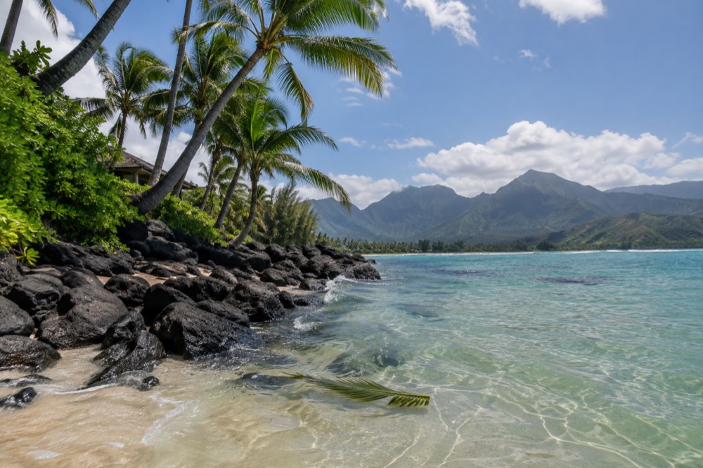Poipu Beach with calm turquoise water and palm trees along the shore