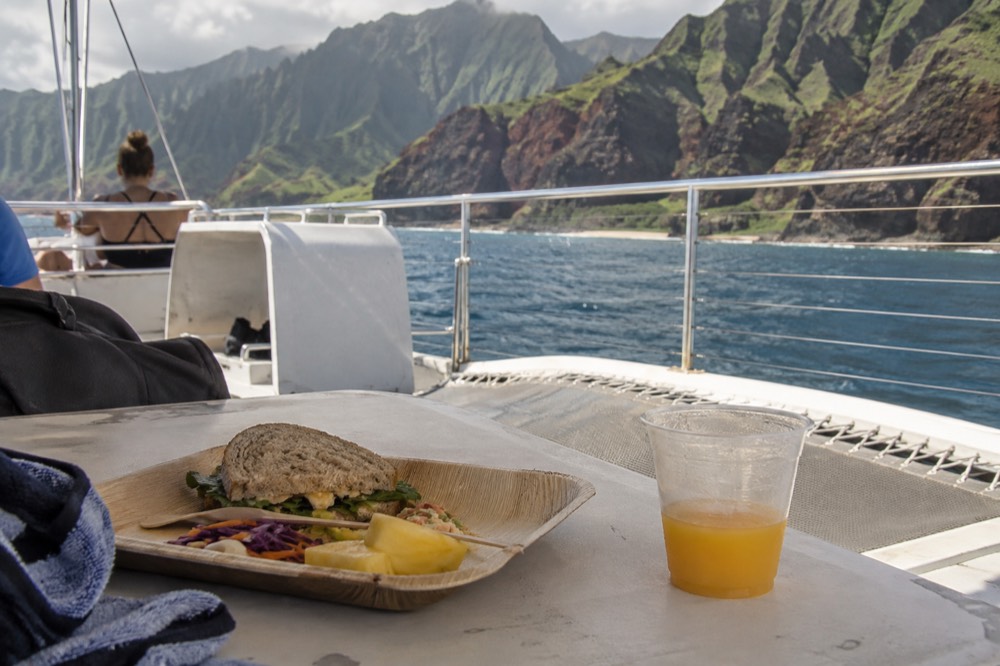 A catamaran deck with a served lunch tray during a Napali Coast tour