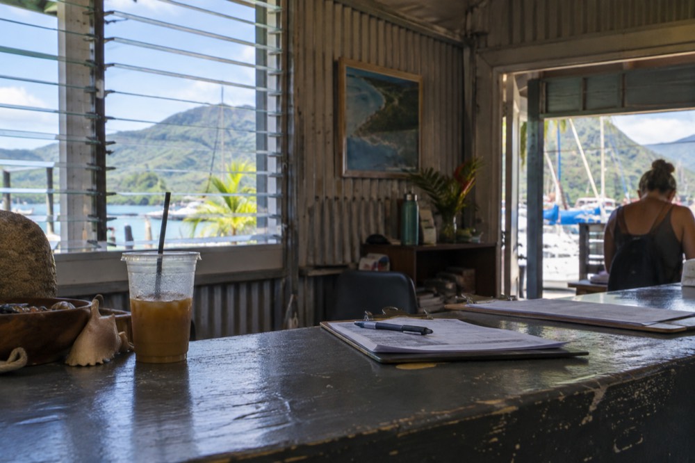 Tour boat office row at a small harbor with guests checking in at a desk