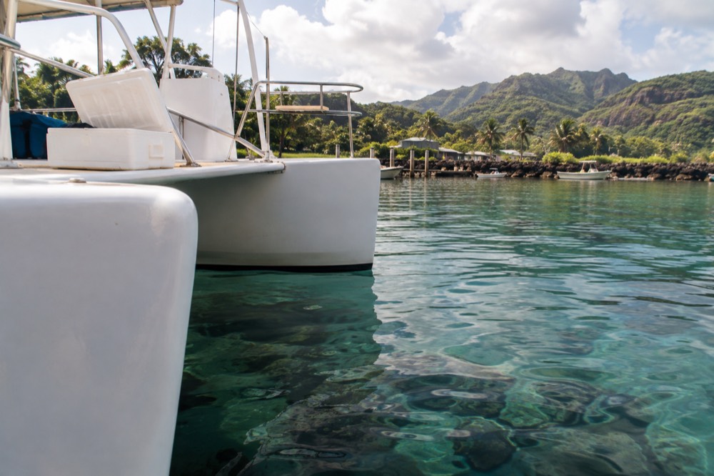 Close along the twin hulls of a power catamaran drifting off Port Allen
